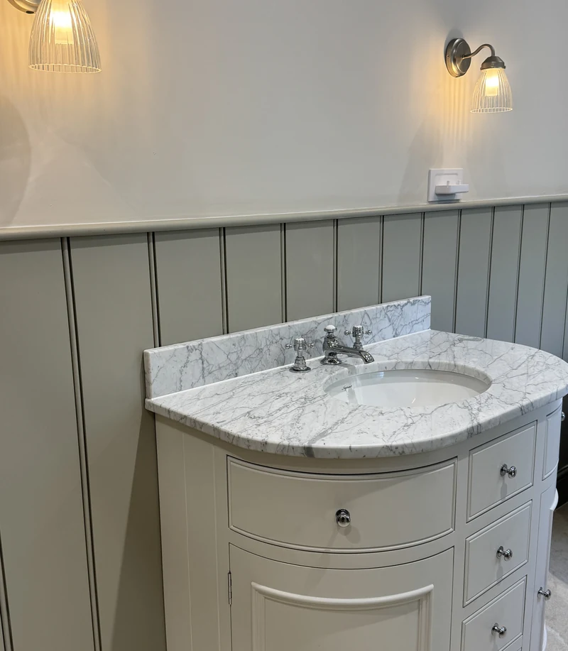 Curved vanity unit with a marble top and traditional tap, bathroom renovation