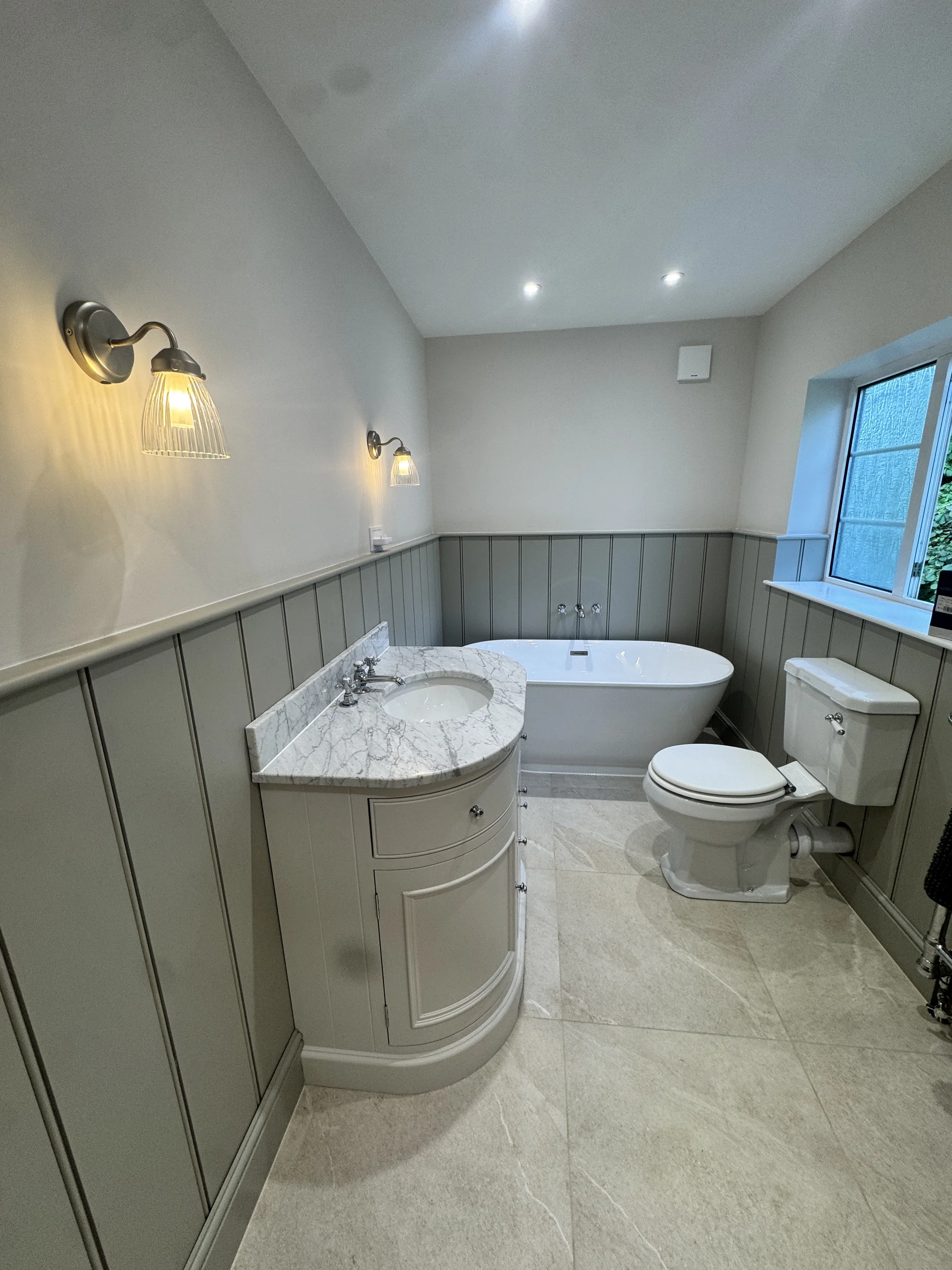 Bathroom renovation with freestanding bath, marble vanity and sage panelling