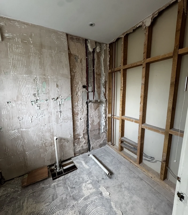 The en suite stripped back to studs and brickwork before the renovation, St Albans