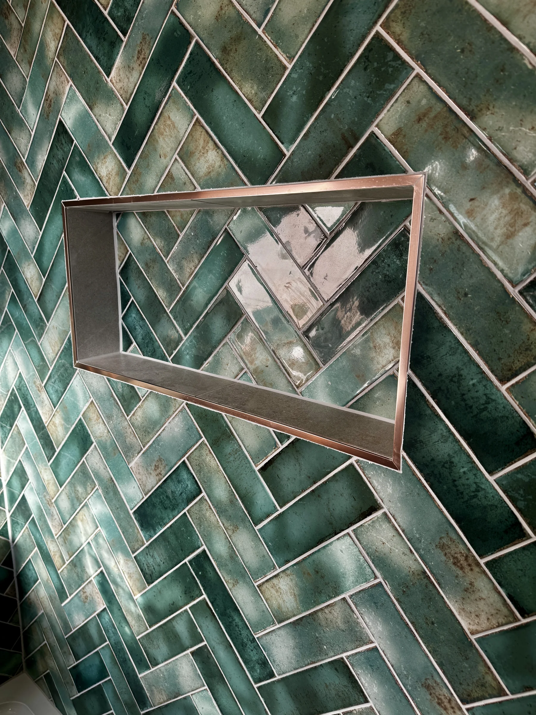 Copper-framed shelf niche in the green herringbone tiling, St Albans