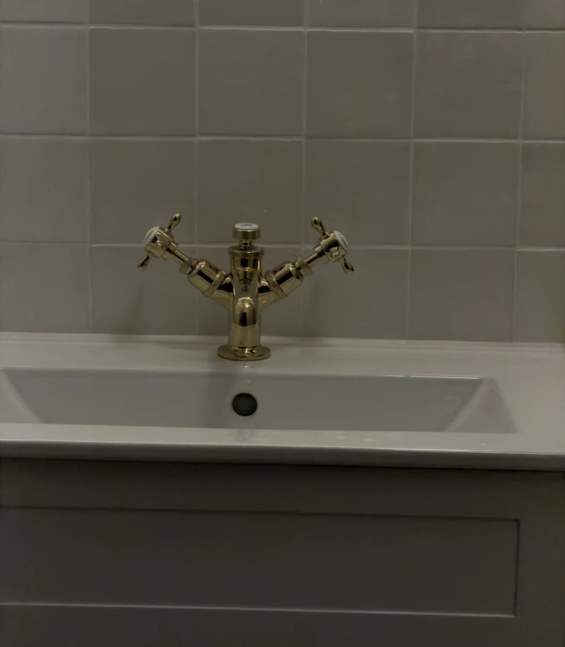 Brass crosshead tap on the countertop basin, bathroom installation