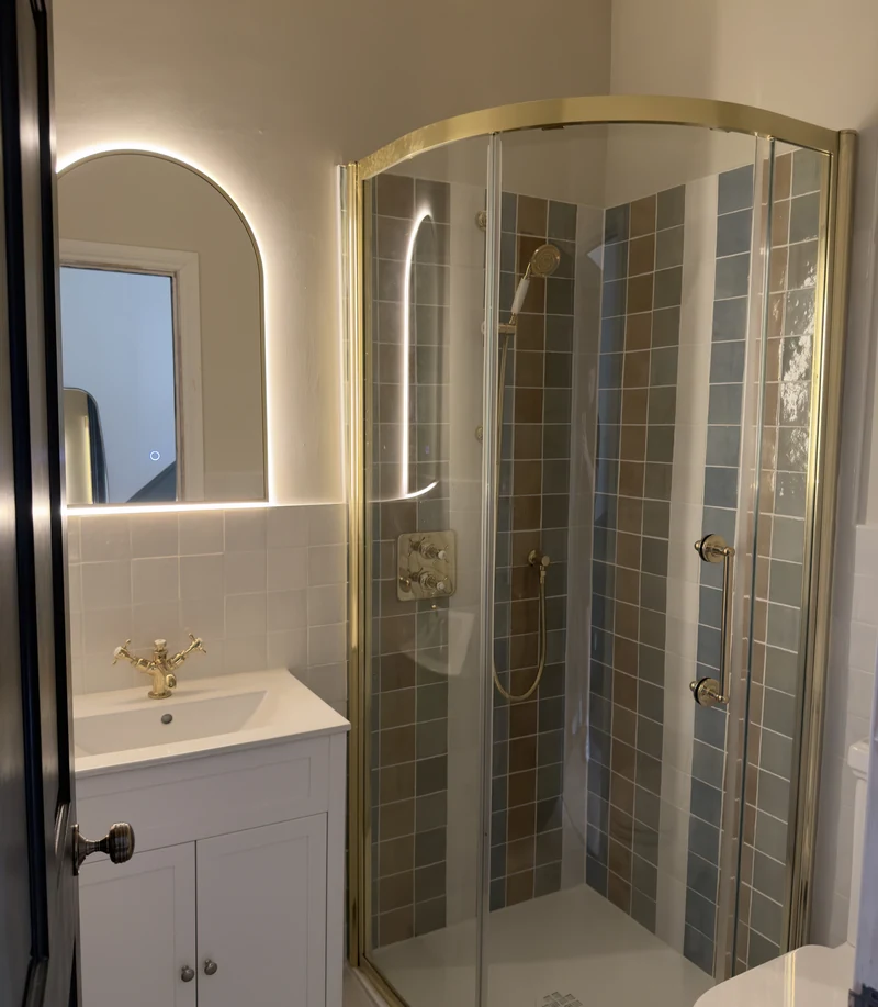 Brass-framed quadrant shower enclosure with mosaic tiling
