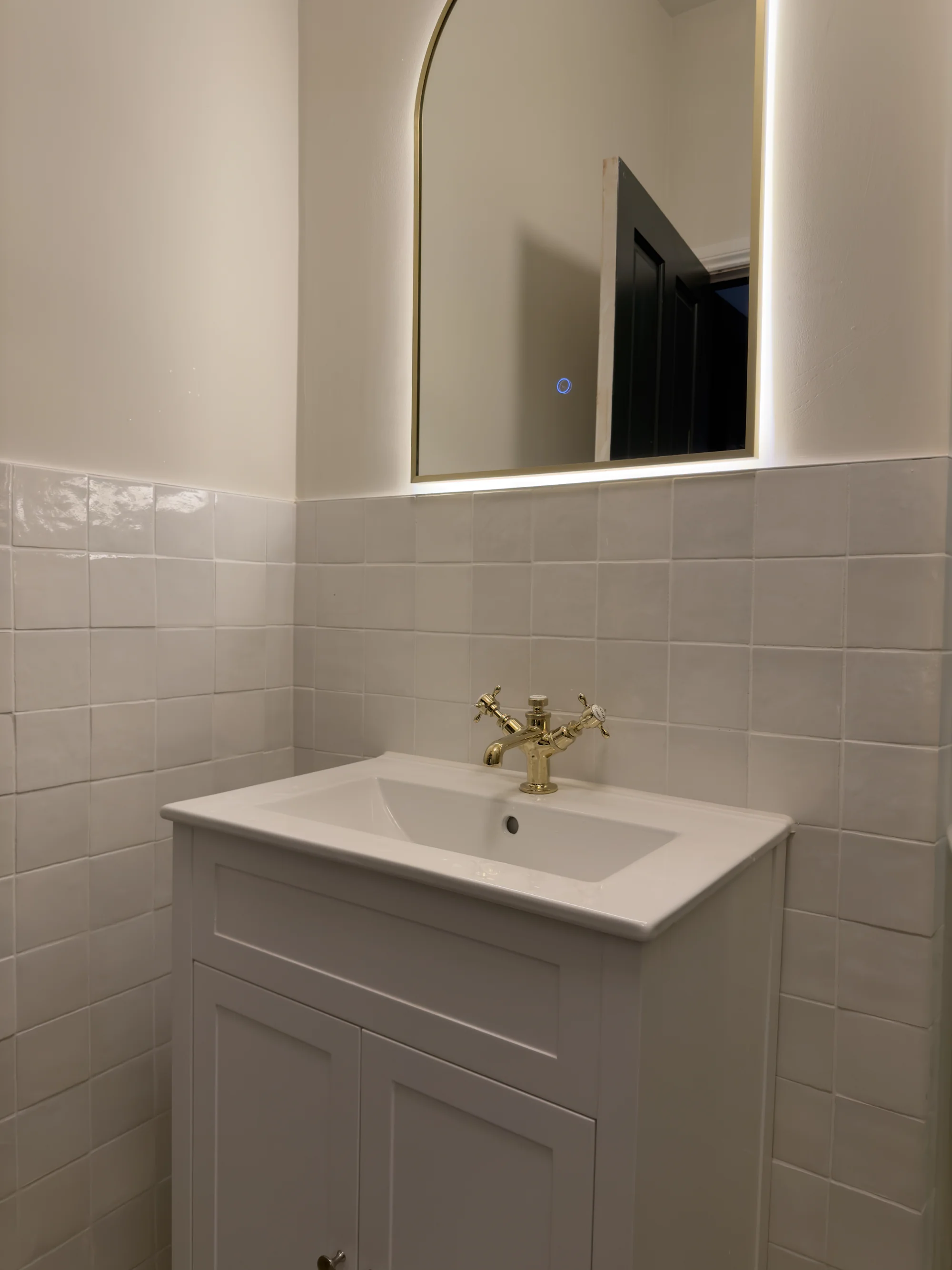 Shaker vanity with a brass crosshead tap and backlit mirror
