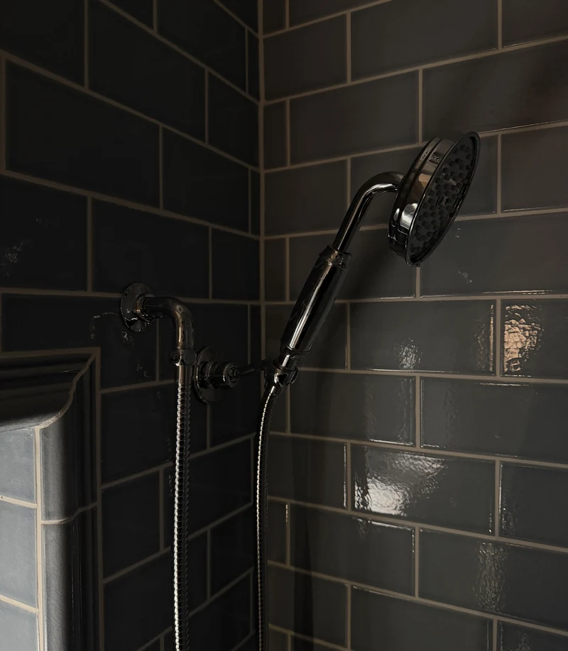 Chrome shower handset against dark metro tiling, St Albans