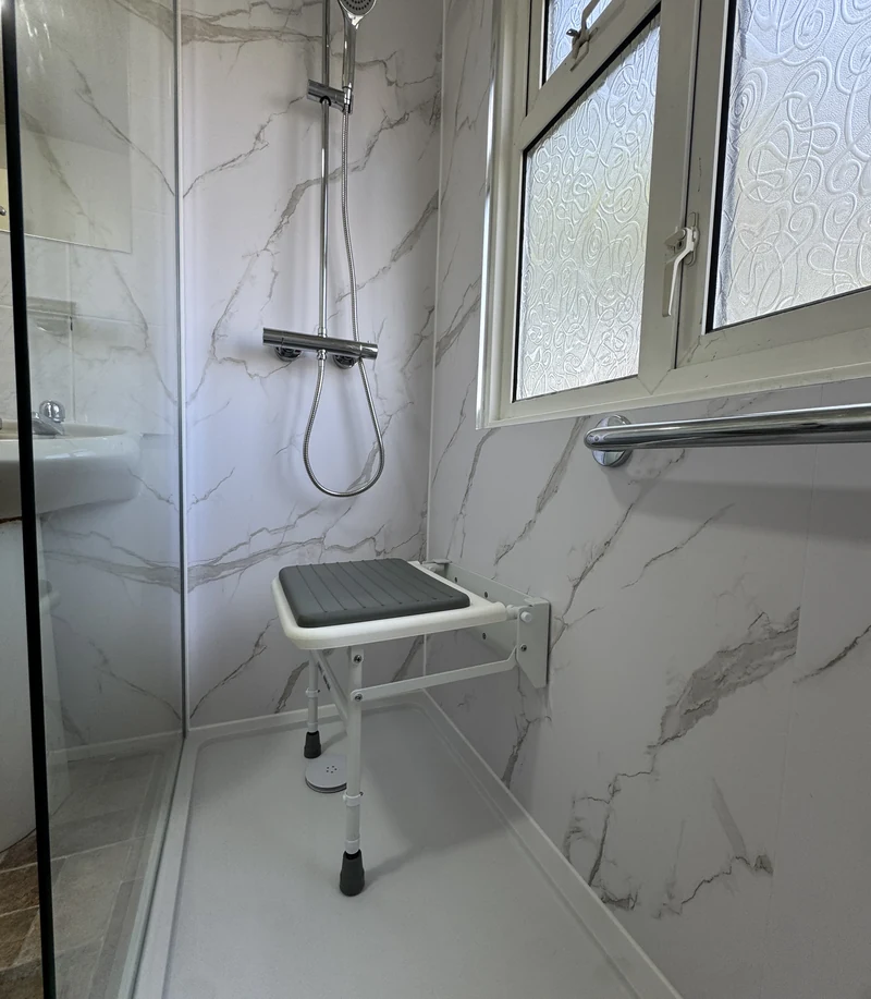 Fold-down seat and shelf in the level-access shower, Hertfordshire