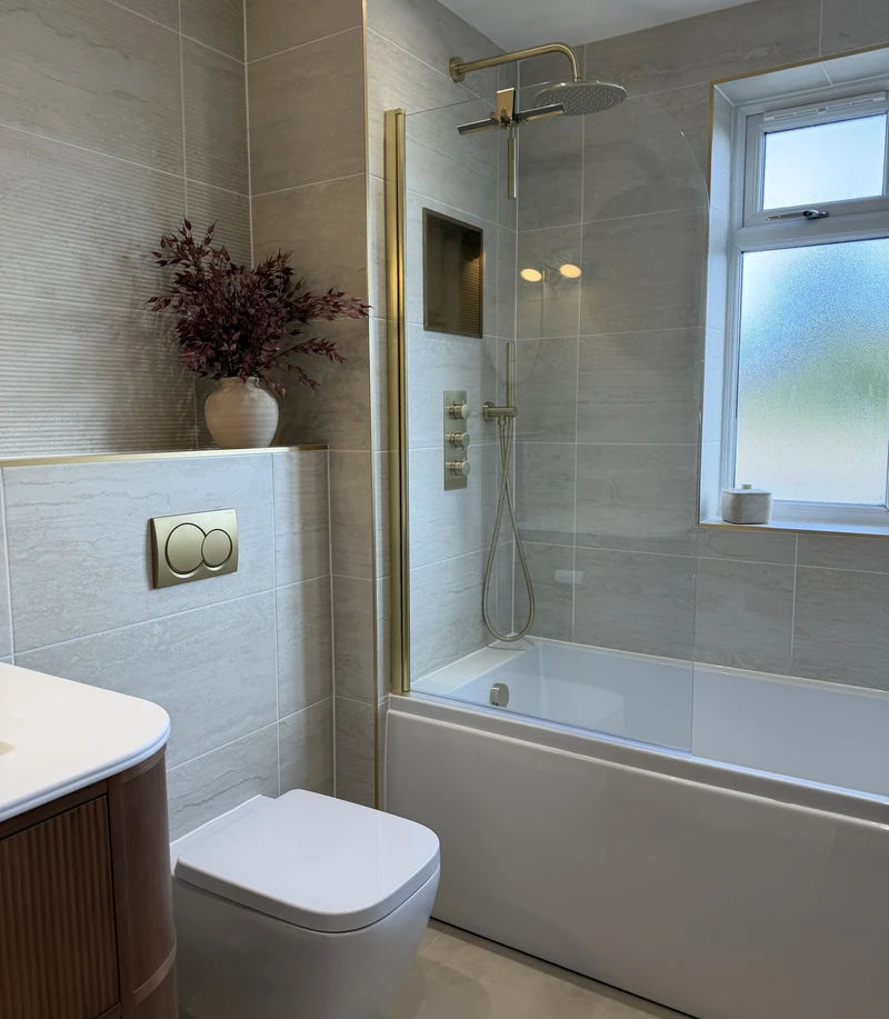 Bath with a brass shower over and obscured window, bathroom renovation