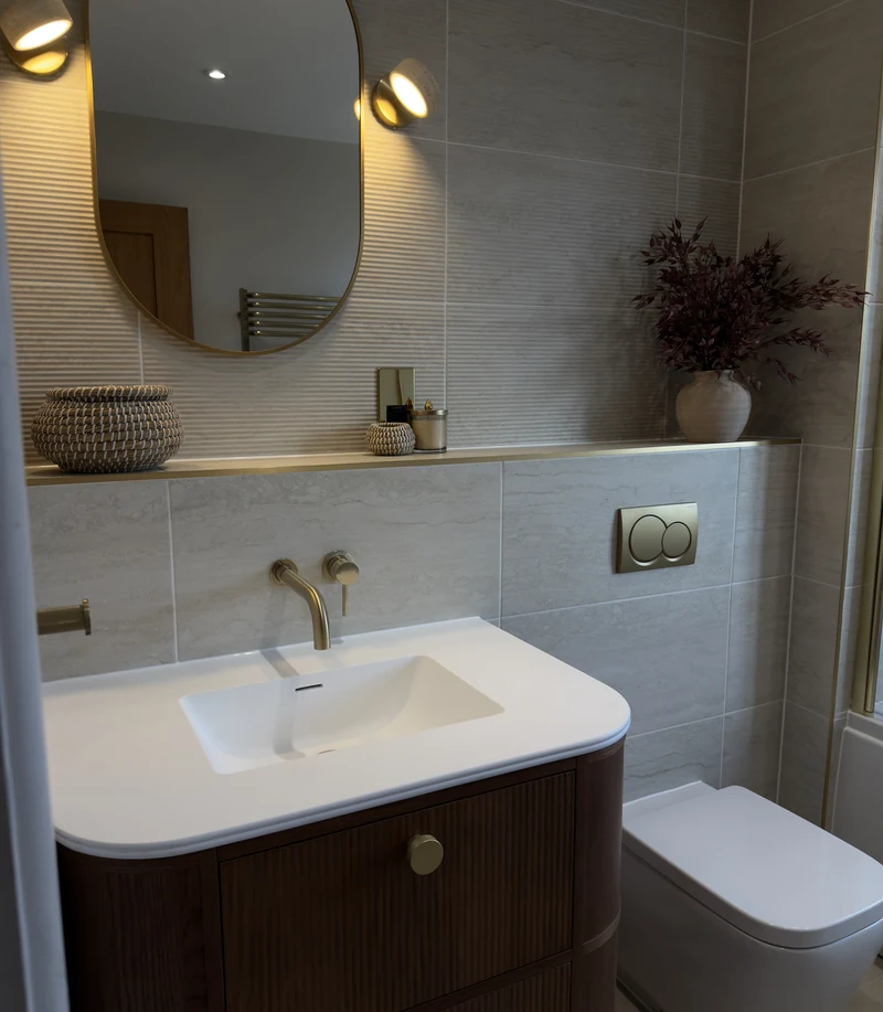 Concealed cistern WC with a brass flush plate and floating shelf