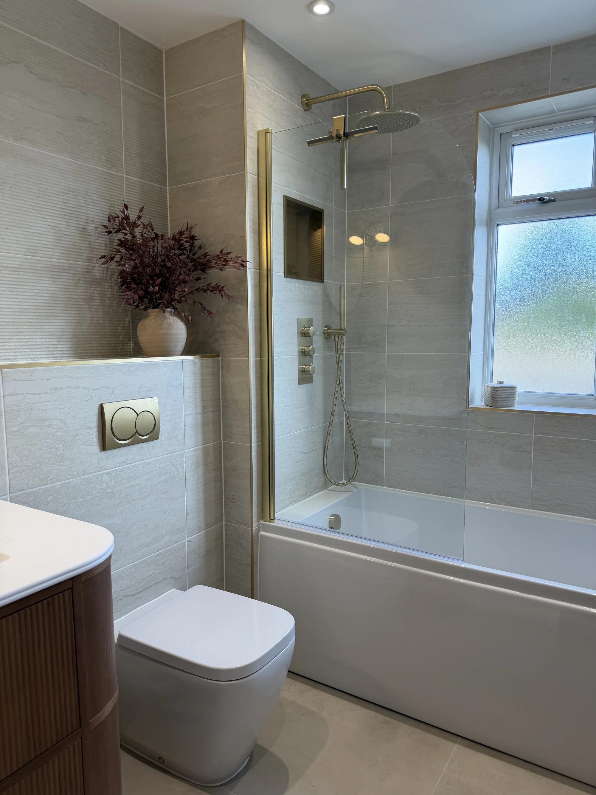 Bath with brass shower over beside the window